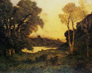 Goats grazing beside a lake at sunset